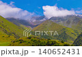 Time-lapse of clouds flow on blue sky above green mountains in Kyrgyzstan at summer day. 140652431