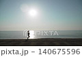 Silhouette of plus size woman running along edge of shore near sea in rising sunlight. Background of curvy person with overweight running, active morning routine on sea coast, wide shot. 140675596