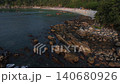 Woman meditating on rocks overlooking tropical beach, Thailand  140680926