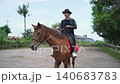 Rider on brown horse moving through rural yard from early start to near-end 140683783