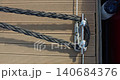the pier at the yacht club, the thick rope of the moored boat, the fender hanging on the side of the boat 140684376
