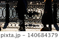 picturesque metal railings with a double-headed eagle and the crown of the Russian Empire on embankment in St. Petersburg, Russia, walking people, sunny autumn day, incredible sun glare Russia 140684379
