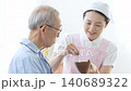 A caregiver assisting an elderly person with eating 140689322