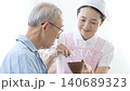 A caregiver assisting an elderly person with eating 140689323
