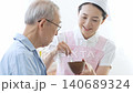 A caregiver assisting an elderly person with eating 140689324