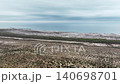 Aerial view of coastal landscape with sandy terrain and distant water horizon 140698701