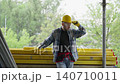 Construction worker adjusting hard hat on site 140710011