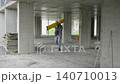 Construction worker carrying leveling tool on building site 140710013