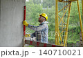 Construction worker using spirit level on concrete wall 140710021