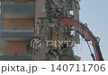 Excavator with hydraulic crusher is tearing down the building: slow motion 140711706