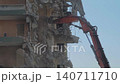 Slow motion: excavator with hydraulic crusher is tearing down the building 140711710