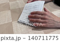 Hands deliberately ripping handwritten page into pieces. Closeup view of hands intentionally ripping handwritten document into small pieces over textured surface for cleanup purposes 140711775