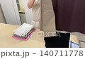 Bed methodical folding and stack formation. Organized folding of trousers and tops, creating uniform stacks, smoothing edges, final placement into neat storage pile for easy retrieval 140711778