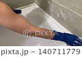 Hands working on tile grout cleaning, Removing residue from tile edges and sealing joints meticulously, Carefully scrubbing grout and sealing lines at tile edges for tidy appearance 140711779