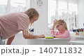Close-up of tattooed hands holding a small colorful object in a sunlit room 140711832