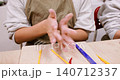 Pottery lesson. Diy ceramics. Unrecognizable talented children hands forming clay molding raw using color tool in creative art studio. 140712337