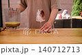 Cocktail pouring. Beverage serving. Unrecognizable chef man hand preparing in decorating glass cold liquid with cocoa powder in cafeteria. 140712713