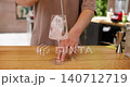 Blending ice. Refreshing beverage. Unrecognizable bartender male hands stirring cold cubes preparing classic cocktail in clear glass at bar counter. 140712719