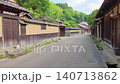 一隻貓站在石階上，背景是傳統的日本城鎮景觀。 140713862