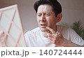 鏡を見ながら口元にできた口唇ヘルペスの症状に悩み、顔をしかめるミドル男性 鏡を見ながら口元にできた口唇ヘルペスの症状に悩み、顔をしかめるミドル男性 140724444