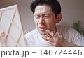 鏡を見ながら口元にできた口唇ヘルペスの症状に悩み、顔をしかめるミドル男性 鏡を見ながら口元にできた口唇ヘルペスの症状に悩み、顔をしかめるミドル男性 140724446