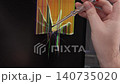 A technician testing a cracked computer monitor with a voltage screwdriver, illustrating hardware diagnosis and complex electronics repair work in a professional service center. Zoom 140735020