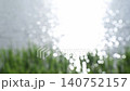 Bright sunlight sparkling on lake water with soft grass foreground 140752157