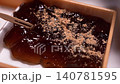 A close-up of the moment when kinako (roasted soybean flour) is sprinkled on authentic warabi mochi made with real bracken starch (Japanese confectionery video footage). 140781595