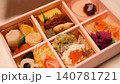 A close-up of a woman opening the lid of a high-end bento box (hands only). 140781721