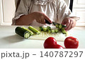 Girl hands cutting cucumber on kitchen cutting board 140787297