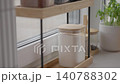 Hand takes salt and sugar jars from kitchen organizer near window 140788302