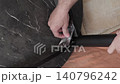 man screws a leg to the table 140796242