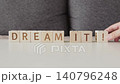 motivational phrase dream it !, laying out  by hand from letters on wooden cubes, slow motion 140796248