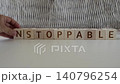 motivational word unstoppable, laying out  by hand from letters on wooden cubes, slow motion 140796254