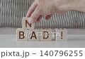 motivational phrase not bad !, laying out  by hand from letters on wooden cubes, slow motion 140796255