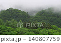 A mountain landscape with clouds drifting across the overcast sky. 140807759