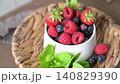 Fresh Summer Berries with Mint in a Ceramic Bowl on a Woven Tray 140829390
