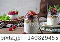 Healthy Breakfast Chia Pudding with Fresh Berries and Granola in Glass Jars 140829455