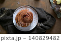 Freshly Baked Cinnamon Roll on a White Plate with Rustic Decor 140829482