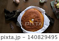Freshly Baked Sponge Cake with Easter Eggs and Feathers in a Rustic Table Setting 140829495