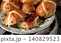 Fresh Homemade Hot Cross Buns with Jam and Sultanas on a Vintage Plate 140829523