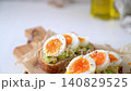 Slices of Toasted Sourdough Bread with Mashed Avocado and Soft Boiled Egg 140829525