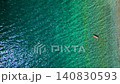 Woman in a red swimsuit lays on her back in the clear sea, top down view 140830593