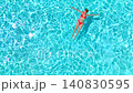 Top down view of a woman in pink swimsuit laying on her back in the pool. 140830595