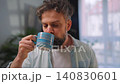 Happy man drinking coffee at relaxed home environment closeup. 140830601