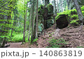 Walking through a forest trail in Hruba Skala, Bohemian Paradise (Cesky raj), Czech Republic. Towering sandstone rock formations line the path in one of the country's most popular hiking destinations. 140863819