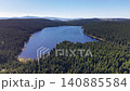 Majestic mountain lake aerial sweep over forested peninsula, shimmering water and distant ridgelines 140885584