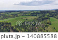 Aerial view patchwork fields and woodlands with hedgerows, grazing land, gentle ridges, paths and seasonal 140885588