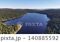Aerial reservoir scene with visible bridge calm deep blue water surrounding evergreen forest remote serene 140885592