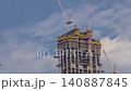 Tower construction site daytime timelapse Dubai with rooftop cranes aerial 140887845